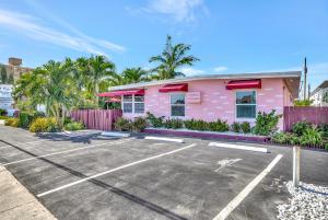 帕诺滩Seahorse Guesthouse的一座粉红色的建筑,设有停车场