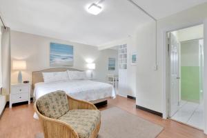 帕诺滩Seahorse Guesthouse的白色卧室配有床和椅子
