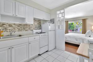帕诺滩Seahorse Guesthouse的厨房配有水槽、冰箱和1张床