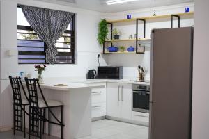 开普敦Nature's Rest的厨房配有白色橱柜和冰箱。