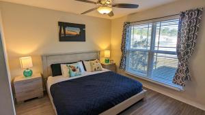 纳瓦拉Beachy Bliss the perfect stay的一间卧室配有一张带吊扇和窗户的床。