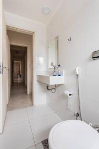 瓜鲁雅Apartamento encantador no Guarujá, praia da Enseada - Apenas 600m da praia !的白色的浴室设有卫生间和水槽。