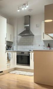 巴尔金Modern and Stylish 1bed flat的厨房配有白色橱柜和炉灶烤箱。