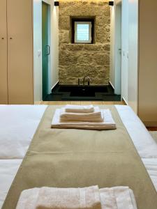 Vale de PrazeresQuinta da Porta - Solar de Vale de Prazeres的浴室在床上配有2条毛巾和水槽