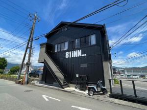 富士河口湖SAMURISE 81INN - Vacation STAY 60981v的街道边的黑色建筑,有一辆摩托车