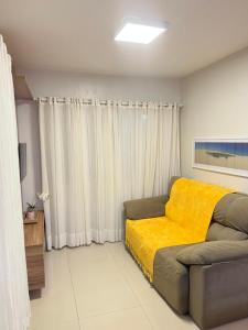 巴雷里尼亚斯Casa em Condomínio agradável com fundo pro rio的一间卧室配有一张床和黄色毯子