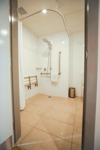 阿皮亚Lava Hotel的带淋浴的浴室和瓷砖地板。