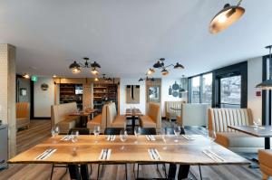 坎卢普斯Prestige Kamloops Hotel的一间带木桌椅的餐厅和一间用餐室
