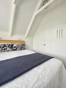 陶朗加The Loft Matua的白色卧室配有床和白色橱柜