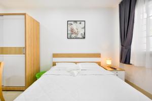 胡志明市Huyen Homestay的卧室设有一张白色大床和一扇窗户。