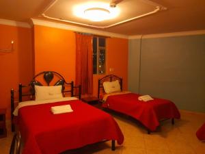 基多Hotel Allegria的橙色墙壁客房的两张床