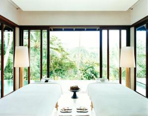 帕洋安COMO Shambhala Estate的一间卧室设有四张床和大窗户。