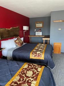 DickeyvilleTri-State Wood Inn的红色墙壁的酒店客房内的两张床