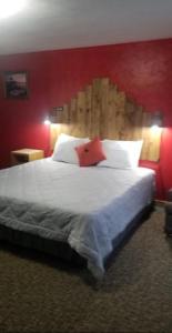 DickeyvilleTri-State Wood Inn的一间卧室设有一张红色墙壁的大床