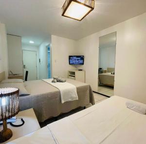 巴雷里尼亚斯Flat no Resort Gran Lençóis的酒店客房设有两张床和电视。