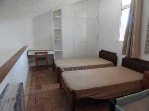 马林堡Casa de férias in RETUR, praia do Cabeço, Algarve的小房间设有三张床和一张桌子