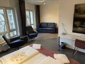 柏林阿尔法酒店的客厅配有床、沙发和椅子