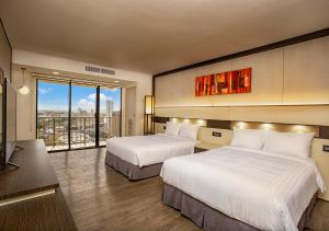 塔穆宁景湾关岛酒店的酒店客房设有两张床和大窗户。