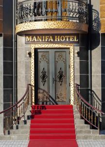 塔什干Manifa Hotel的红色地毯的楼梯通往酒店,设有门