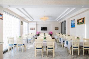 塔什干Manifa Hotel的宴会厅配有白色的桌椅