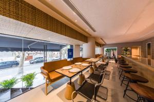 上海静安寺淮海中路亚朵X酒店的餐厅设有桌椅和大窗户。