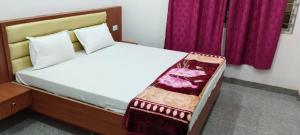 王舍城Hotel Shree Krishna Palace的一间卧室配有一张带紫色窗帘的大床