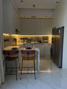 利雅德Smart Entry Apartment的一间带桌子和冰箱的大厨房