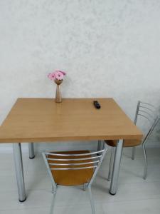 阿拉木图Молодежный的一张木桌,上面有花瓶