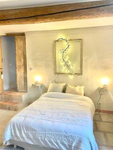 沃韦尔La Maison du Trident en Camargue Piscine et Jacuzzi的一间卧室配有一张带两盏灯的大型白色床。