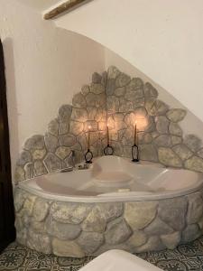 塞特尼尔El Escondite de Martina, Áticos Románticos的石头墙内的浴缸,带蜡烛