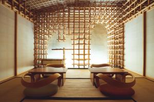 奈良SETRE Naramachi セトレ ならまち的一间设有两张桌子和椅子的房间,以及梯子