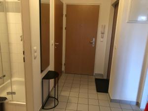 科尔新堡MF City Apartment的浴室里设有门和凳子的走廊