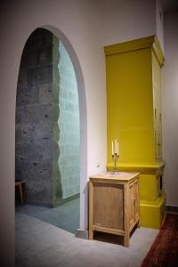 久姆里Kotun Gyumri的一间设有黄色墙壁和一张带蜡烛的桌子的房间