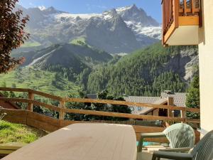拉格拉沃Cosy Appart'Hotel - Panoramic Village - La Grave的山景阳台上的桌椅