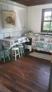 蜜岛Quartos Casa da Ilha do Mel - Nova Brasília的厨房配有柜台和桌椅