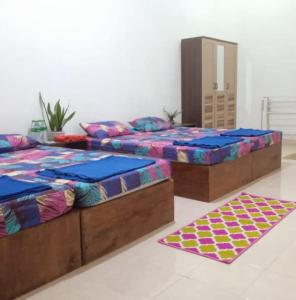 SintangWismaALAS Syariah Guesthouse的两张带两张床垫的床铺