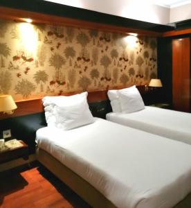 巴伦西亚凯悦酒店的配有白色床单的酒店客房内的两张床