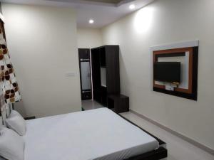 德奥加尔Hotel Shree Hari的卧室配有一张床,墙上配有电视。