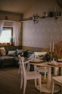 LūšakrogsVIESU MĀJA KALNARUŠĶI的客厅配有桌椅和沙发