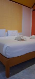 高兰Long Beach Garden Resort的一张配有白色床单和枕头的大床
