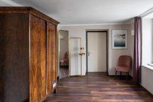 萨尔茨堡numa I Sonate Apartments的走廊设有大型木制橱柜和两把椅子