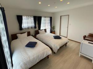 座间味村Dining & Stay 38 Miyahira的一间卧室配有两张床和镜子