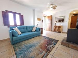 LubrínCasa Caballo a private cottage in Lubrin的客厅配有蓝色的沙发和电视