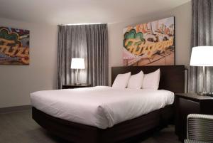 罗宾逊维勒Fitz Tunica Casino & Hotel, Trademark Collection by Wyndham的一间卧室配有一张带白色床单的大床