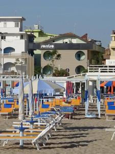 里乔内Hotel Sorriso - molto più di una stella的海滩上的一组椅子和遮阳伞