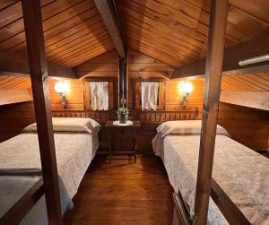 拉加玛艾佩德拉Xalet de Cal Fera的配有木天花板的客房设有两张床。