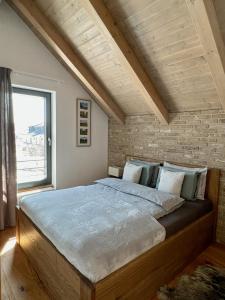 博兹达尔VILLA BOHEMIA - Boží Dar的一间卧室设有一张带砖墙的大床
