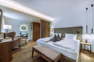 阿皮亚诺苏拉斯特拉达隆格霍夫阿西兹酒店的卧室配有一张白色大床和一张书桌
