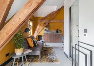 NuthB&B De Oude Dorpsslagerij的客厅设有黄色的墙壁和灰色的沙发。