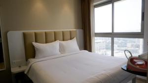 孟买RELOhomes Serviced Apartment的卧室配有一张大白色床和窗户